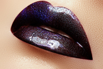 Close-up shot of woman lips with glossy plum lipstick