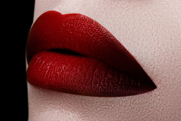 Extreme close up on model with dark red lipstick. Makeup