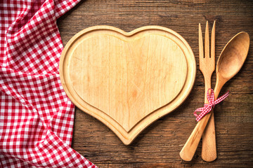 Heart shaped cutting board with a red checkered tablecloth