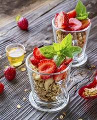 Healthy breakfast dessert. Home crunchy granola with nuts and fresh strawberries