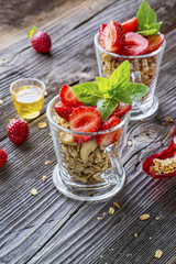 Healthy breakfast dessert. Home crunchy granola with nuts and fresh strawberries