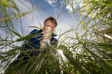 Mann auf Graswiese leidet an Pollenallergie