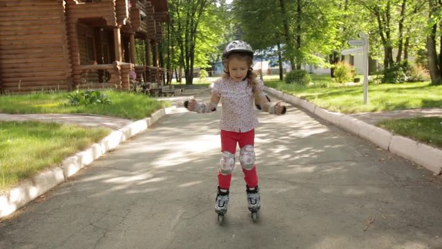 little girl learns to roller skate in the Park