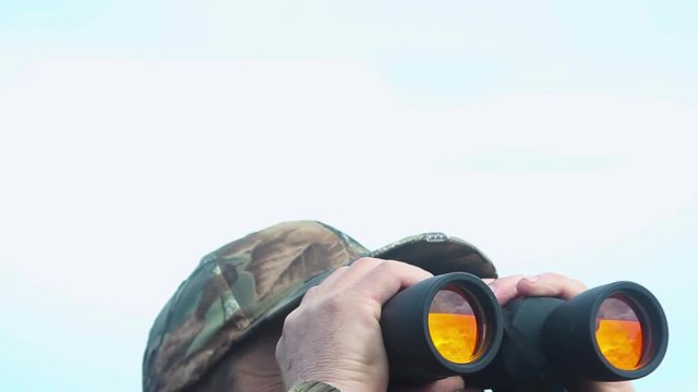 Hunter looks in binoculars