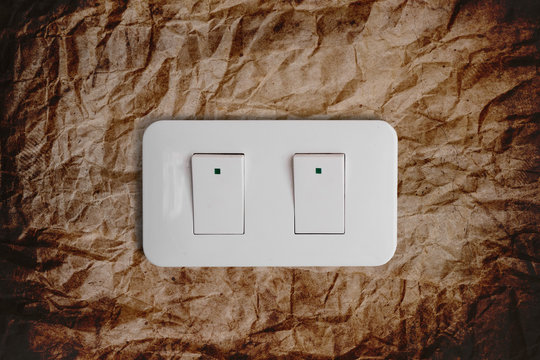 Close-up light switch on brown crumpled texture