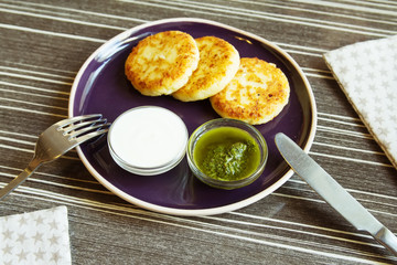 Homemade Salty Cheese Pancakes with sauce Pesto. Cheesecake pancakes with sour cream. Pancakes photographed close.