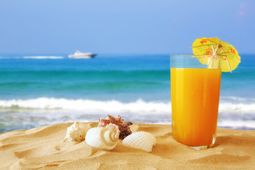 Fototapeta na wymiar tropical sandy beach, fruit cocktail and seashells