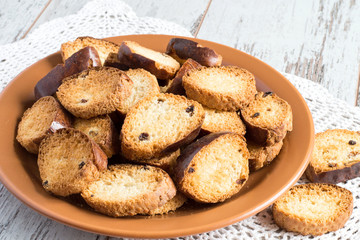  Rusks.   Homemade rusks on a brown ceramic plate on a napkin on a light wooden background.