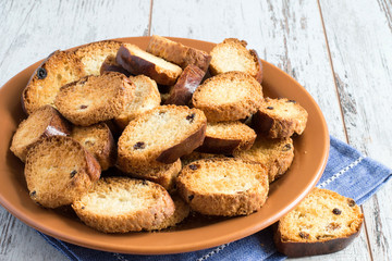  Rusks.   Homemade rusks on a brown ceramic plate on a napkin on a light wooden background.