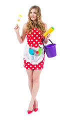 Obraz premium Blonde girl in a red dress housewife with curlers in the house cleaning. Housekeeper with cleaning tools: a bucket, a mop, detergents, isolated on white background.