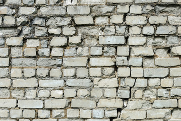 Old white brick wall with cleft