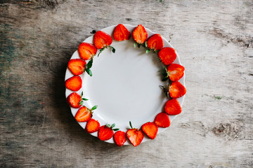 Plate of halved strawberries on the table