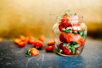 Strawberry in glass jar on black table