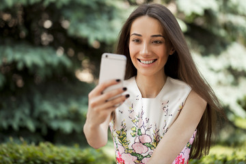 Smiling woman take a picture of herself with a smartphone. selfi