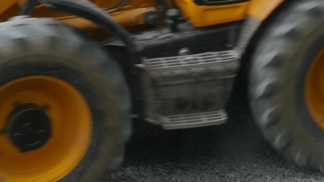 Slow motion shot of the excavator carries gravel in the bucket on road construction