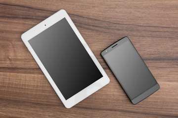 Tablet and mobile phone on wooden desk