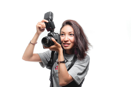 Dark haired woman taking a photo with a modern camera with flash