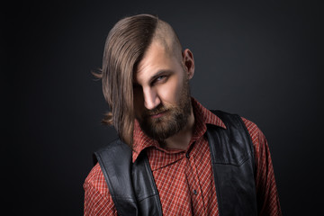 bearded man in waistcoat looking at the camera
