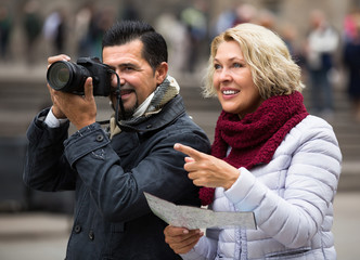 Senior travellers with city map