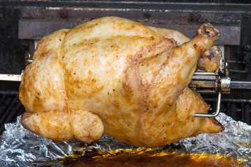 Golden rotisserie chicken on a spit