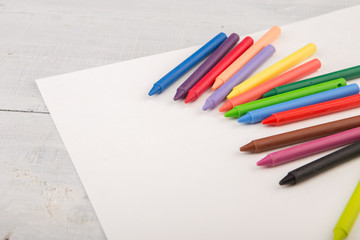 colorful crayons and blank paper on the desk