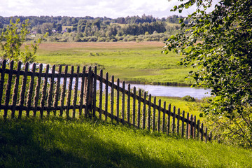 Fototapeta na wymiar old wooden fence in summer Sunny day