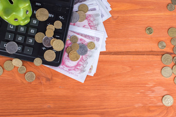 Pig piggy bank, calculator, money on a wooden table. Finance concept.