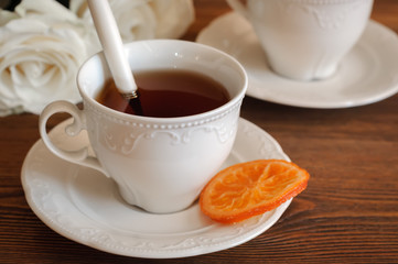 Tea in elegant porcelain cups, candied oranges