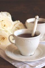 Tea in porcelain cups and roses