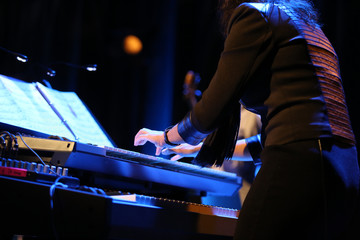 hands of musician playing keyboard in concert