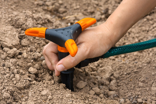 Hand Installing Sprinkler For Irrigation