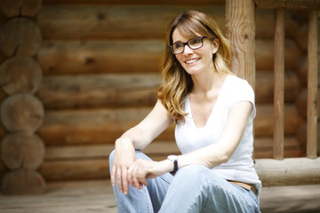 Beautiful middle age woman relaxing in front of her house