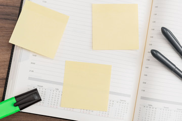 Calendar with memo notes and pen on desk