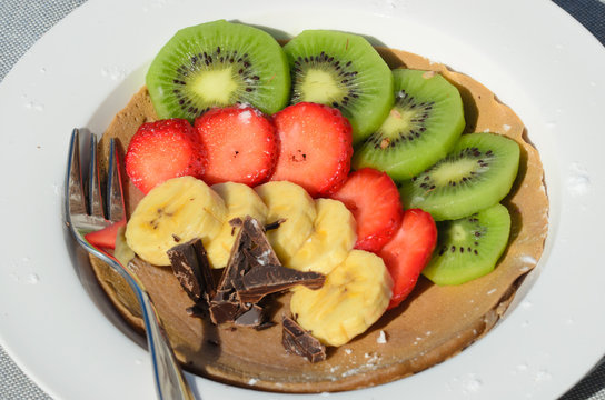 Dessert of kiwi, strawberry, banana and chocolate with fork