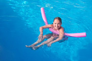 Девочка подросток плавает в бассейне 