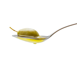 Green olive in full oil spoon, isolated