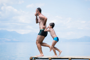 Father and son jumping into lake