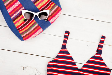 summer women's fashion with colorful striped bag, swimsuit