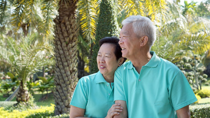 Naklejka na ściany i meble asian senior couple smiling togher in green nature background
