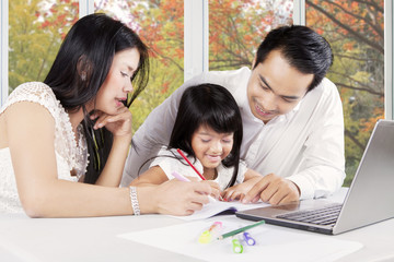 Asian family doing schoolwork together