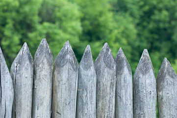 Fence stakes, a fence made of logs, tapered wooden stakes.