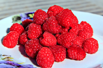 Ripe raspberries on a plate. Selective soft focus