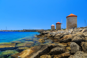 Fototapeta na wymiar Mandraki Harbour windmills on the Island of Rhodes Greece. Sunny day