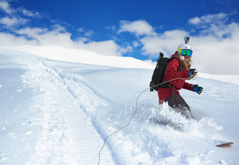 girl snowboarder rides a snowboard towed holding  rope.