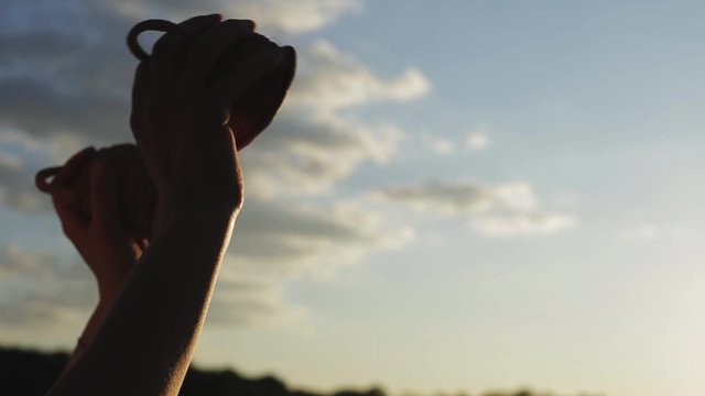 игра на маракасах или кашиши на фоне неба в закате