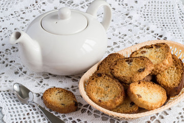  Rusks.   Homemade rusks in a basket and a teapot on a white openwork tablecloth.
