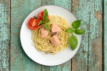 Portion of spaghetti with basil, tomatoes and salmon