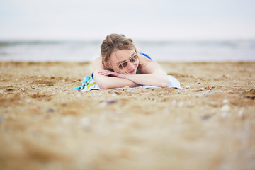 Beautiful young woman relaxing and sunbathing on beach