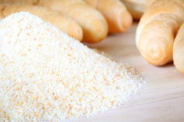 Pile of breadcrumbs and blurry bread rolls in the background