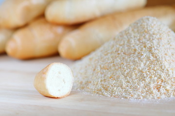 Pile of breadcrumbs and blurry bread rolls in the background